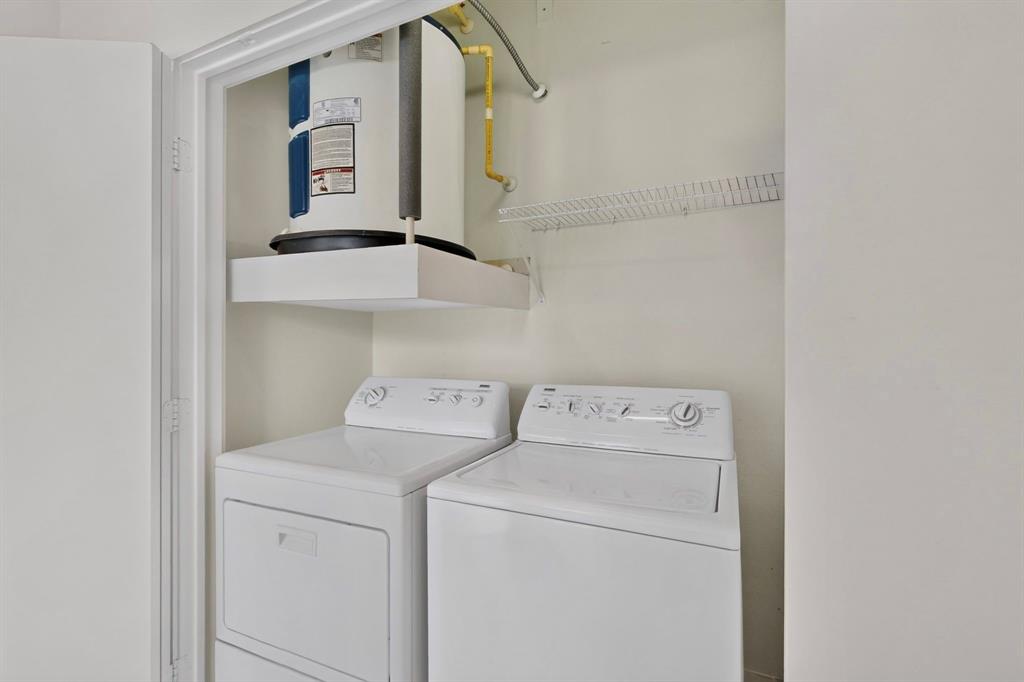 4414 Cedar Springs Road, Unit 318 Dallas, TX 75219 - Photo 32 of 40 Dedicated laundry closet featuring a top-load washing machine, front-load dryer, and a water heater on a raised platform