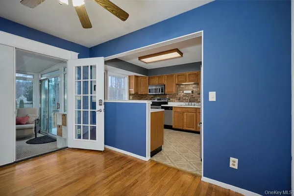 a view of kitchen with refrigerator cabinets and wooden floor