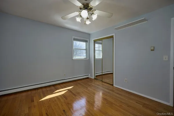an empty room with windows and fan