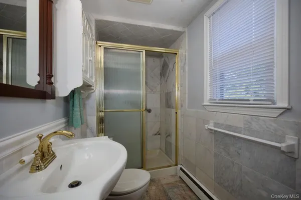 a bathroom with a sink a toilet and shower