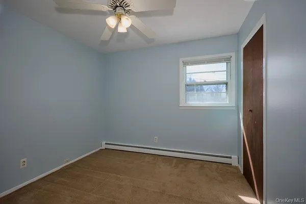 an empty room with windows and fan