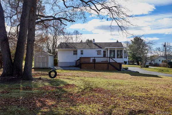 a view of a house with a yard and a tree