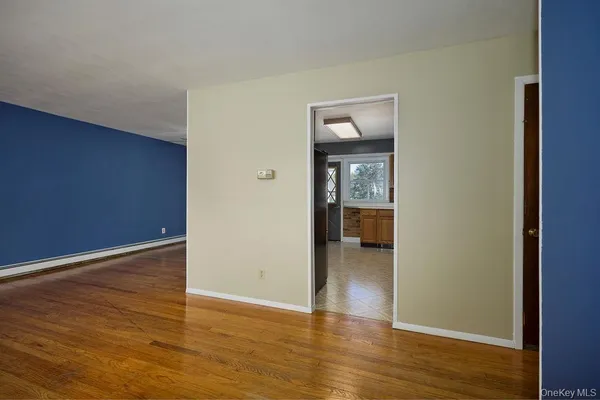 a view of a hallway with wooden floor and a livingroom