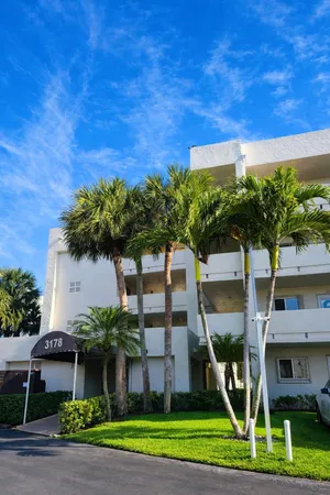 a front view of a house with a yard and potted plants