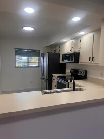 a kitchen with stainless steel appliances a sink dishwasher a refrigerator and a stove