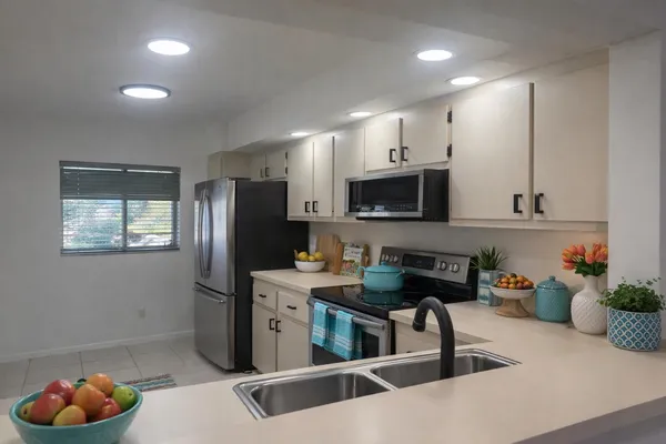 a kitchen with stainless steel appliances kitchen island granite countertop a refrigerator a stove a sink and dishwasher