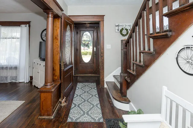 a view of an entryway with wooden floor and a livingroom