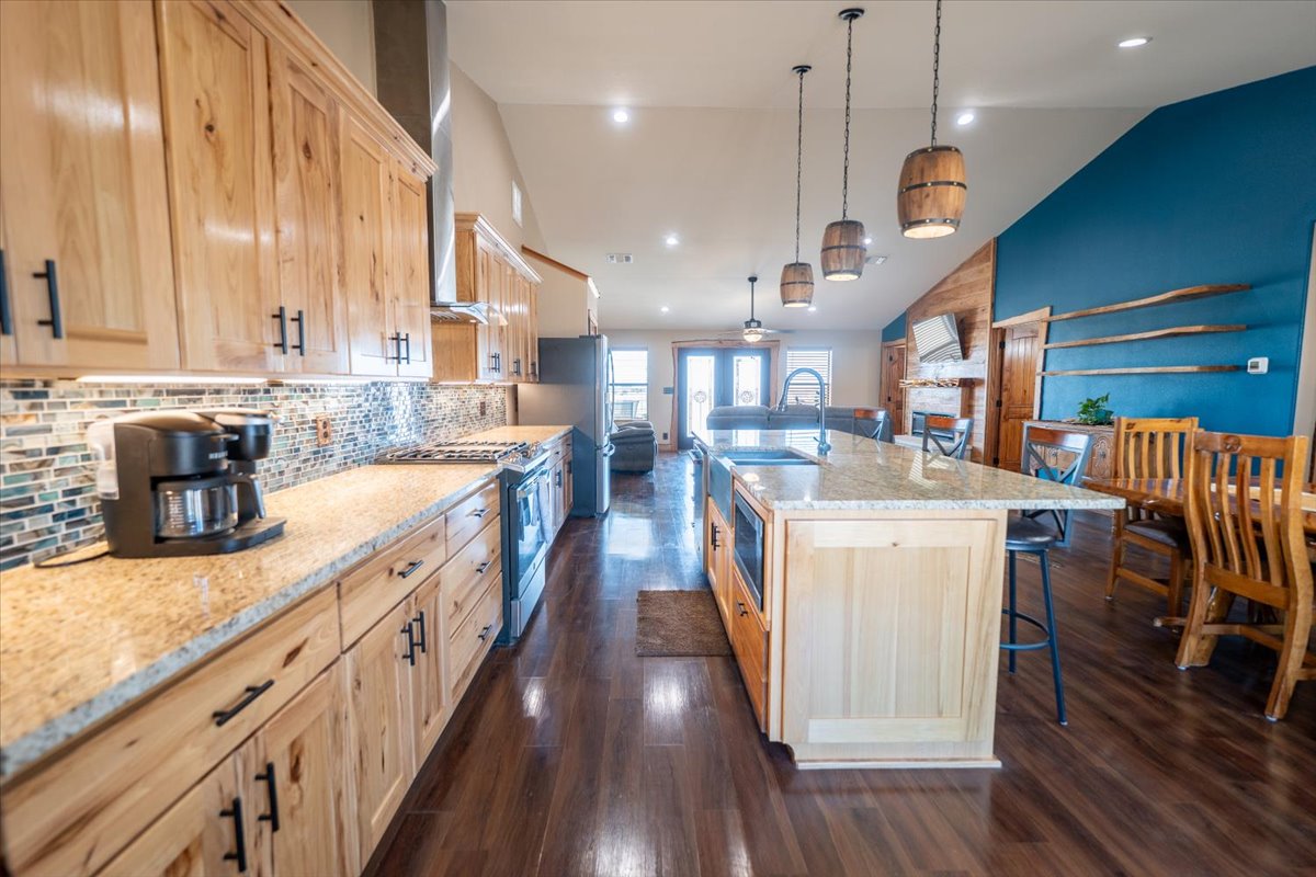 1825 Savanna Ridge Ranch Road Lometa, TX 76853 - Photo 2 of 35 a kitchen with counter top space a sink wooden floor and stainless steel appliances