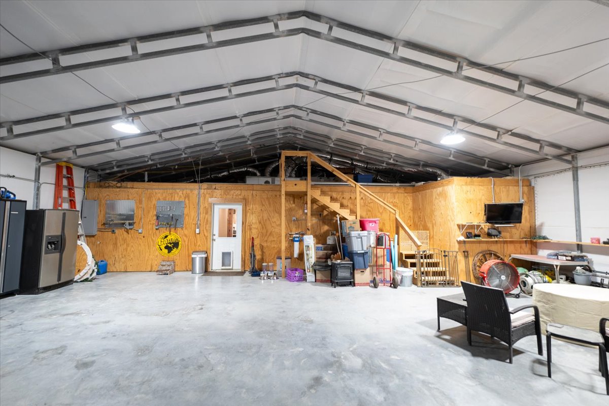 1825 Savanna Ridge Ranch Road Lometa, TX 76853 - Photo 24 of 35 Garage featuring wood walls, electric panel, and stainless steel refrigerator with ice dispenser