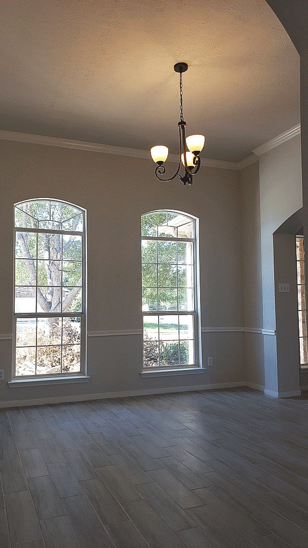 3710 Ransom Road Richmond, TX 77469 - Photo 11 of 42 an empty room with wooden floor chandelier and windows