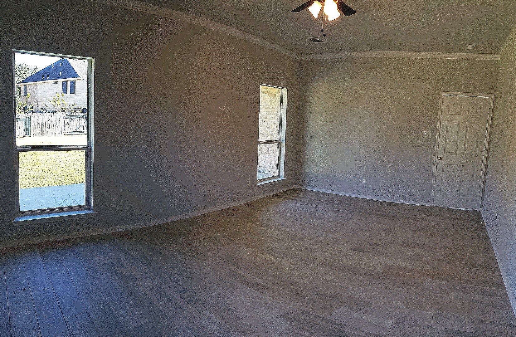 3710 Ransom Road Richmond, TX 77469 - Photo 19 of 42 an empty room with wooden floor chandelier fan and windows