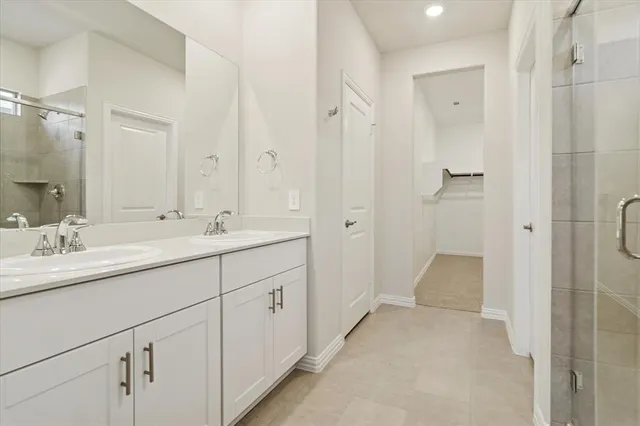 a bathroom with a double vanity sink mirror and shower