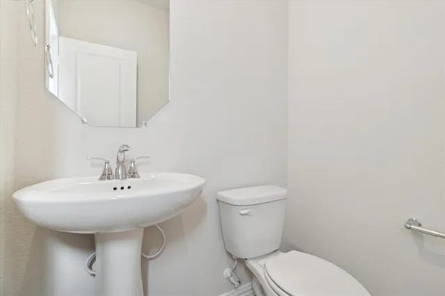 a white toilet sitting next to a bathroom sink