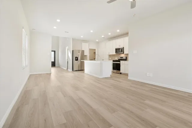 a view of a kitchen with kitchen island wooden floor center island and stainless steel appliances