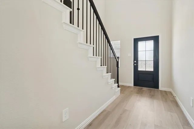 a view of a hallway with wooden floor and entryway