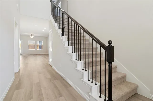 a view of staircase with wooden floor and white walls