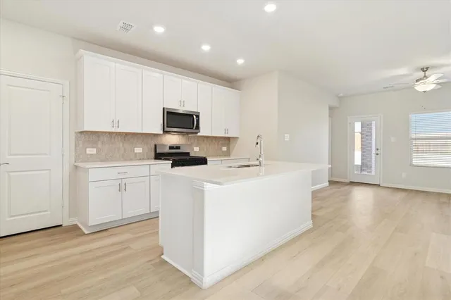 a kitchen with a sink cabinets and wooden floor