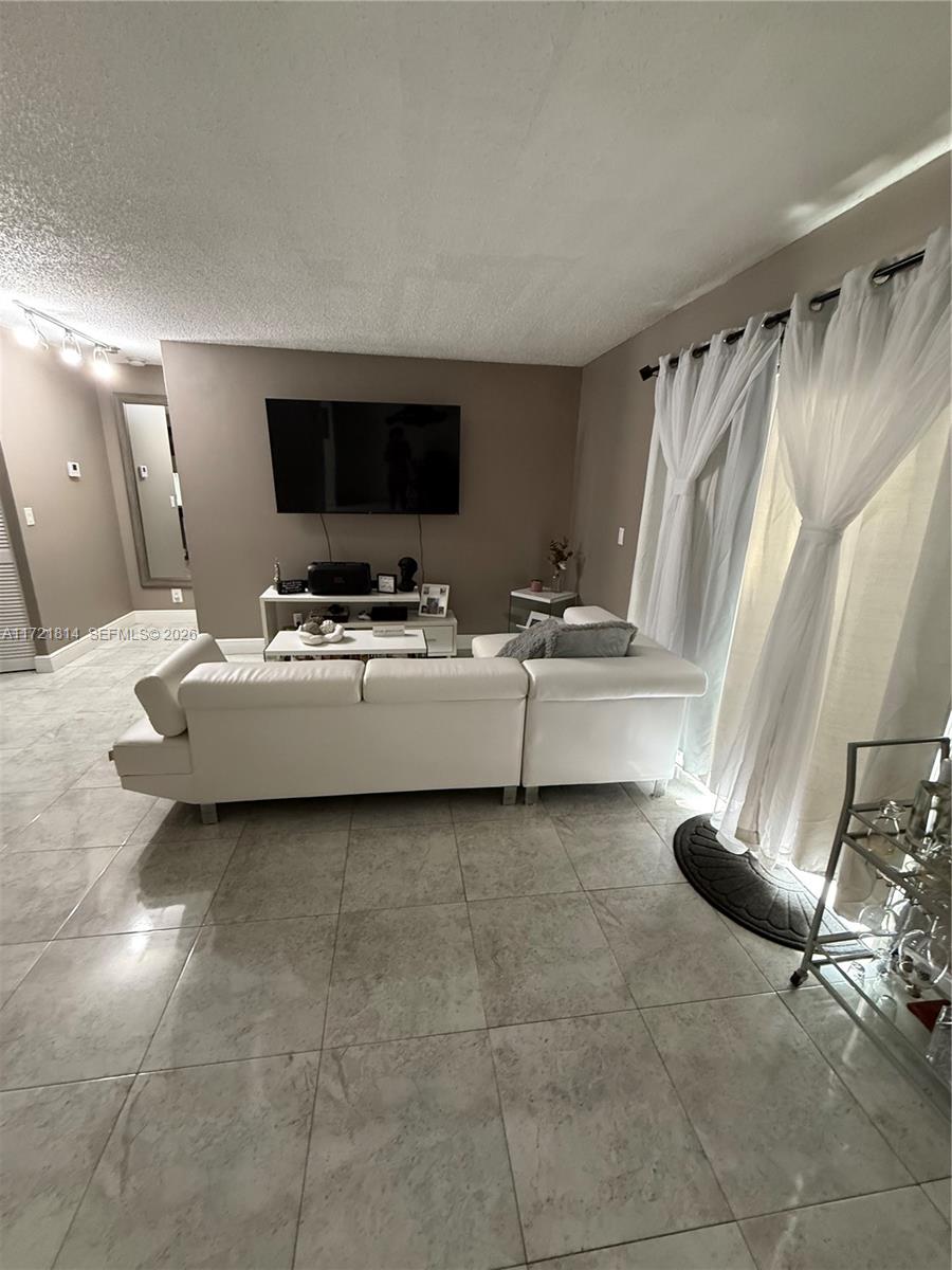 8710 Southwest 3rd Street, Unit 104 Pembroke Pines, FL 33025 - Photo 13 of 46 a living room with furniture and a flat screen tv