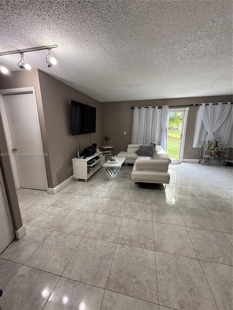 8710 Southwest 3rd Street, Unit 104 Pembroke Pines, FL 33025 - Photo 15 of 46 a living room with furniture and a flat screen tv