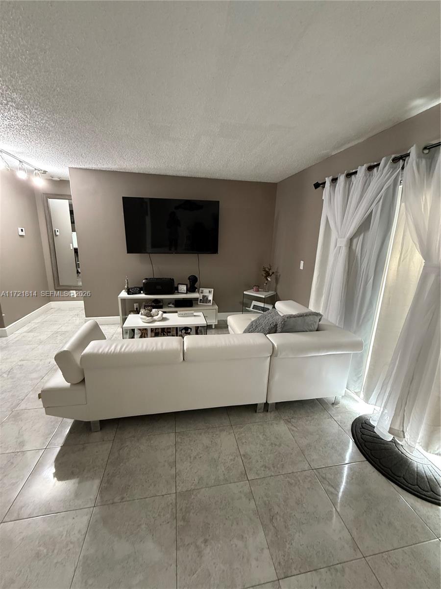 8710 Southwest 3rd Street, Unit 104 Pembroke Pines, FL 33025 - Photo 16 of 46 a living room with furniture and a flat screen tv