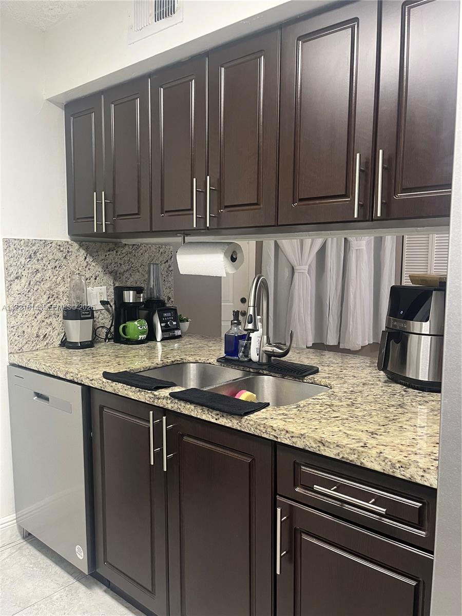 8710 Southwest 3rd Street, Unit 104 Pembroke Pines, FL 33025 - Photo 21 of 46 a kitchen with granite countertop stainless steel appliances a stove sink and cabinets