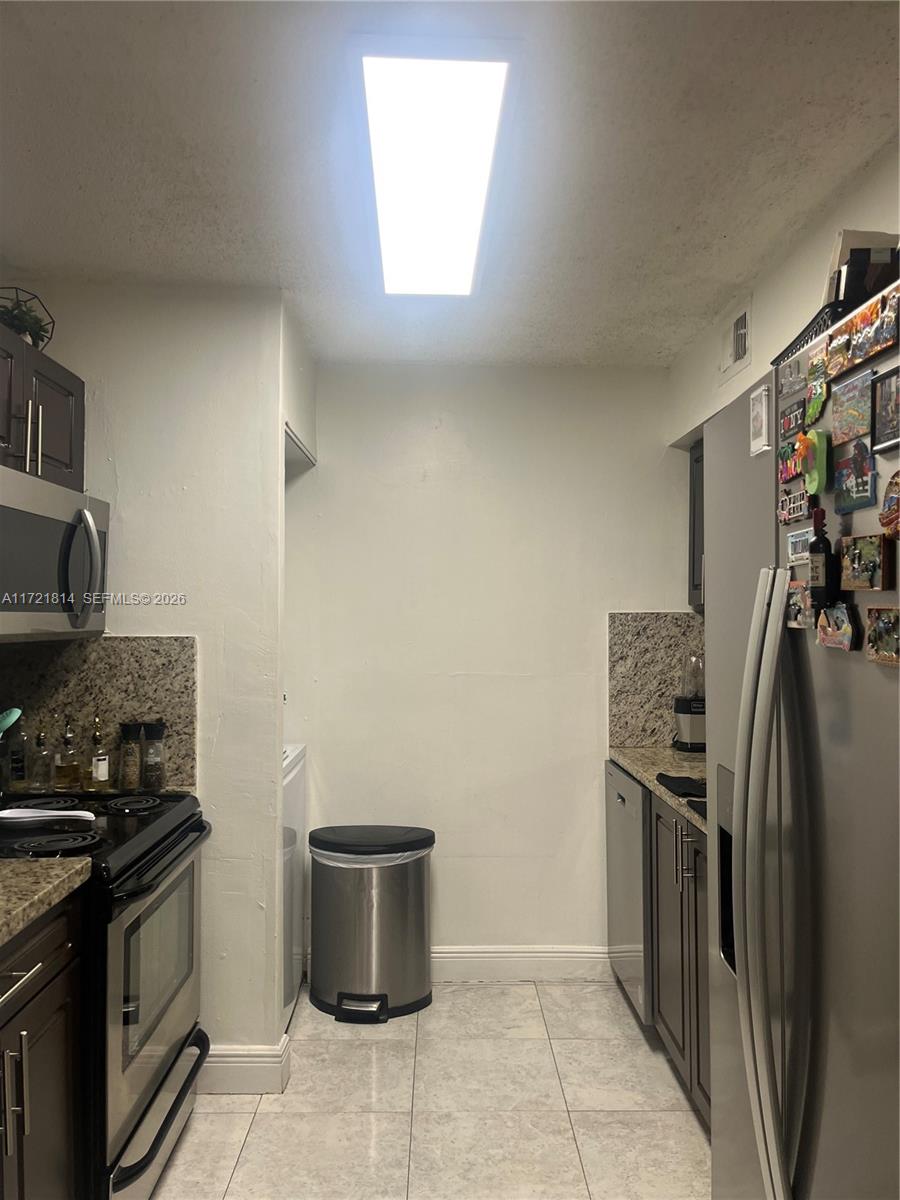 8710 Southwest 3rd Street, Unit 104 Pembroke Pines, FL 33025 - Photo 22 of 46 a kitchen with stainless steel appliances granite countertop a refrigerator and a stove