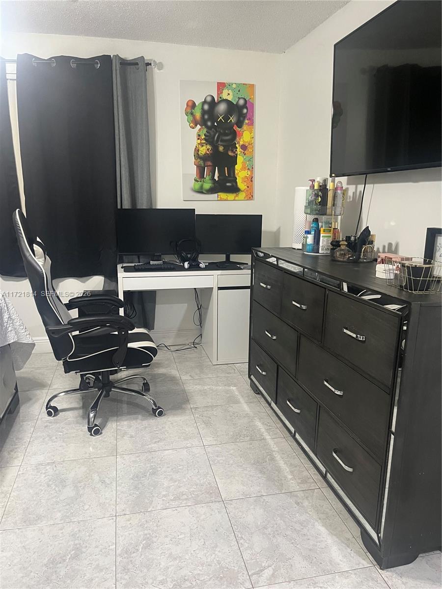 8710 Southwest 3rd Street, Unit 104 Pembroke Pines, FL 33025 - Photo 27 of 46 a room with a couch and a flat screen tv