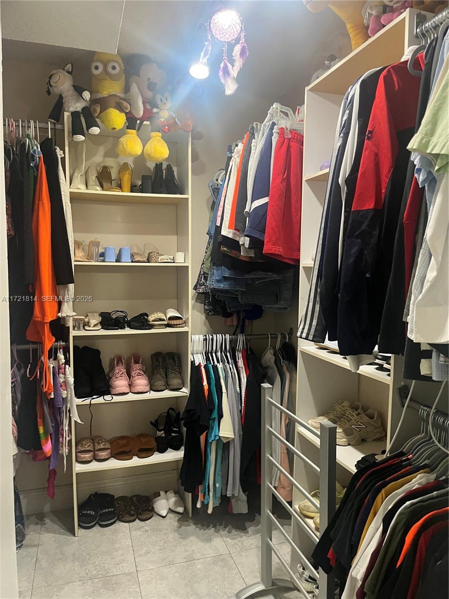 8710 Southwest 3rd Street, Unit 104 Pembroke Pines, FL 33025 - Photo 28 of 46 a view of walk in closet with clothes and shoes
