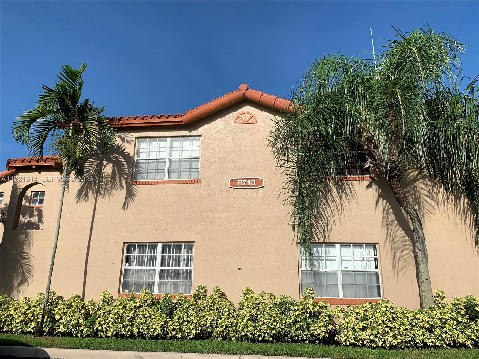 8710 Southwest 3rd Street, Unit 104 Pembroke Pines, FL 33025 - Photo 6 of 46 a view of a house with a yard and potted plants