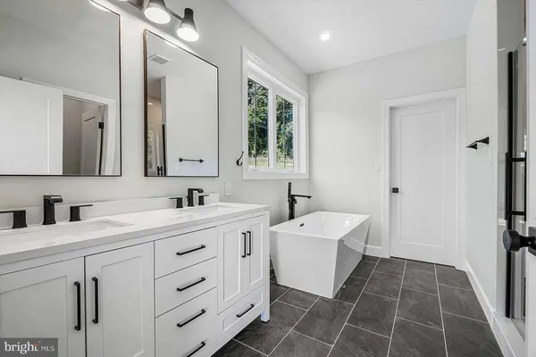 a bathroom with a double vanity sink a mirror and a bathtub