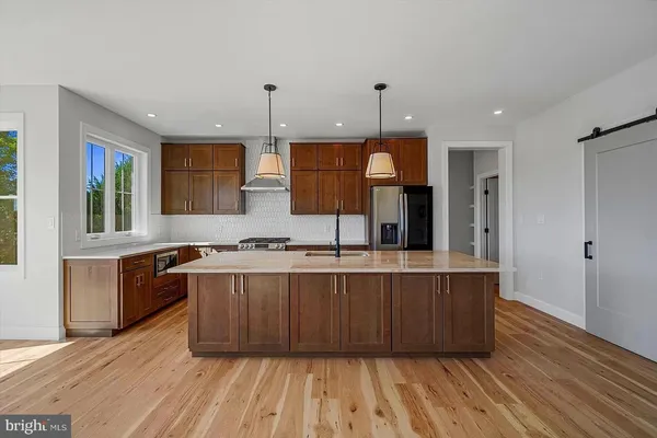 a kitchen with stainless steel appliances granite countertop a sink a stove and a wooden floors