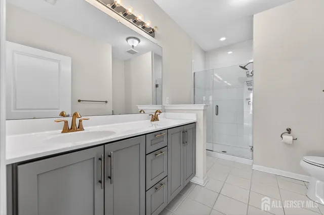 a bathroom with a double vanity sink mirror and toilet