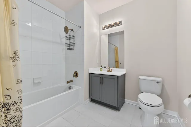 a bathroom with a toilet a sink a mirror a bathtub and vanity