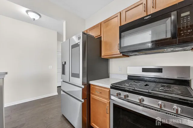 a kitchen with stainless steel appliances granite countertop a stove microwave and refrigerator