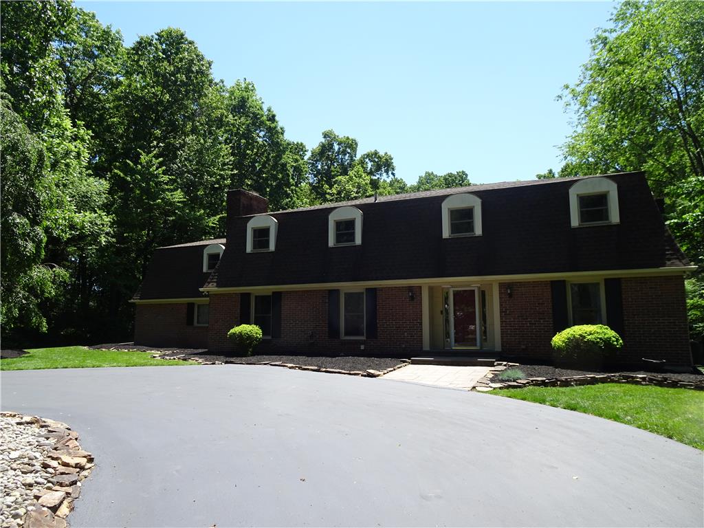 1371 Stoke Park Road Bethlehem, PA 18017 - Photo 12 of 12 A well-maintained brick exterior with a paved driveway, surrounded by mature trees.
