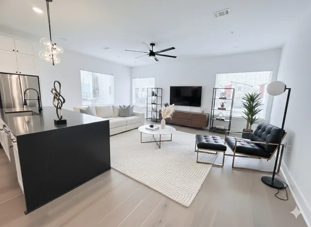 a living room with furniture a chandelier and a flat screen tv