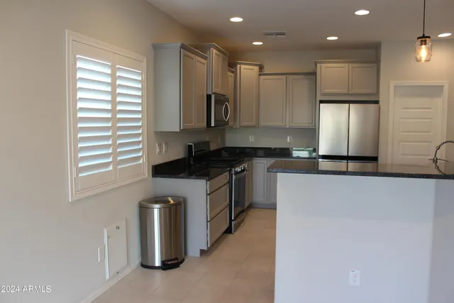 a kitchen with stainless steel appliances granite countertop a stove a sink and a refrigerator