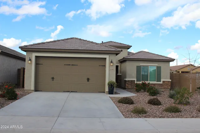 a view of a house with a large window and potted plants