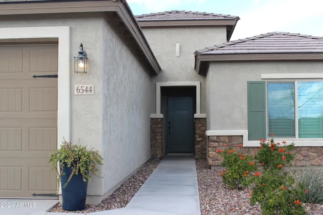 a front view of a house with a garden