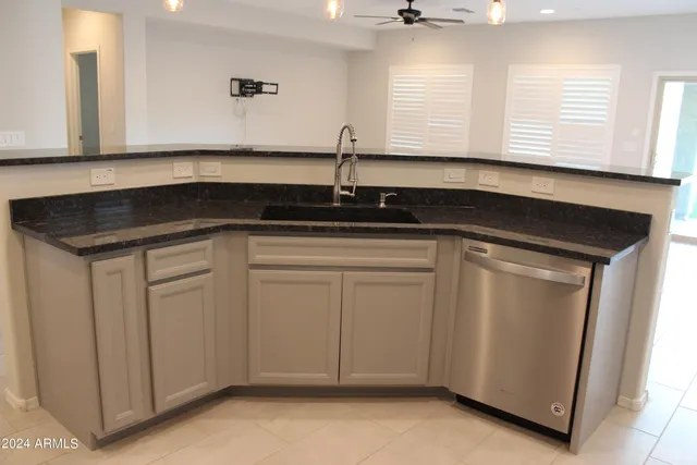 a kitchen with white cabinets sink and window