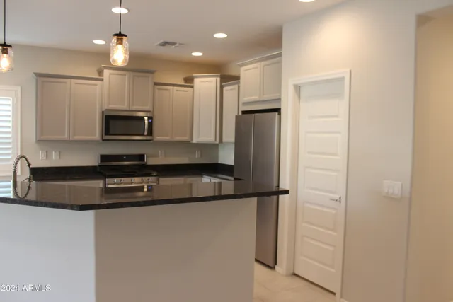 a kitchen with kitchen island a counter top space appliances and a counter top space