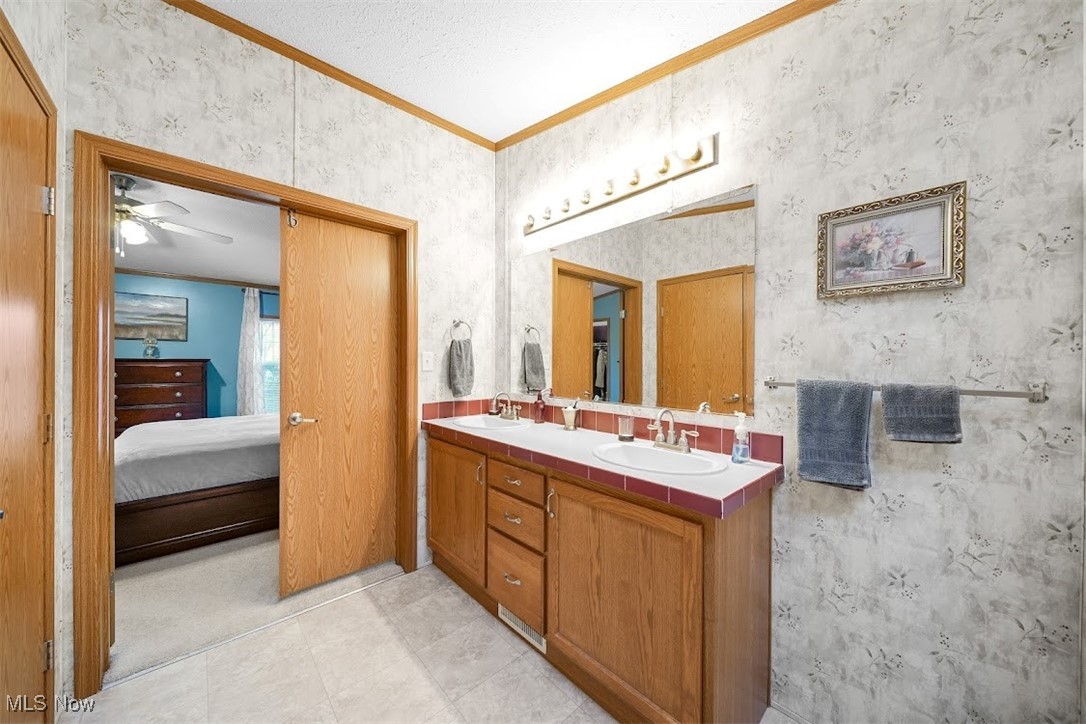 17296 Old State Road Middlefield, OH 44062 - Photo 19 of 44 Bathroom featuring ceiling fan, tile patterned floors, crown molding, a textured ceiling, and vanity