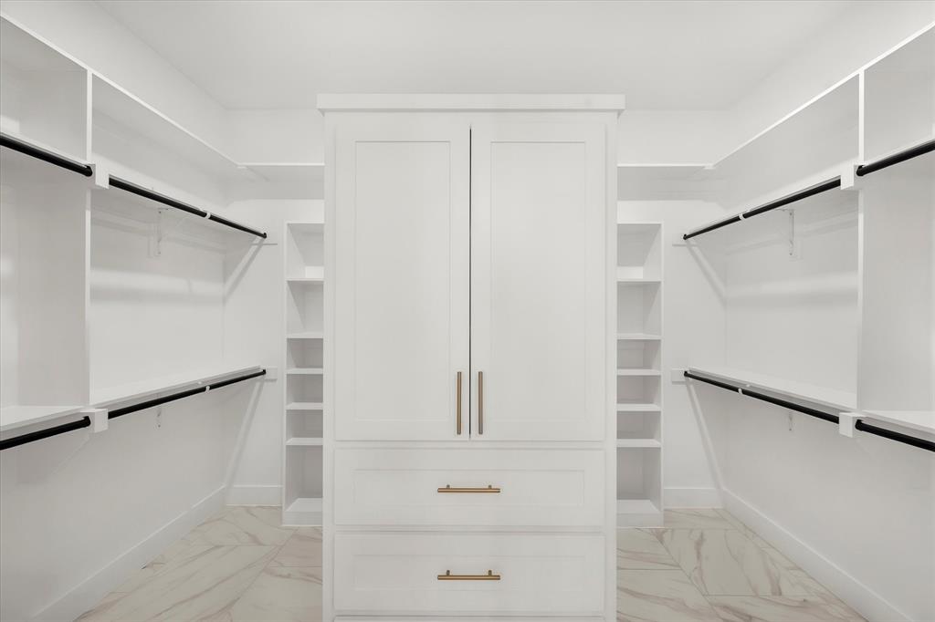 7631 Woodstream Road Midlothian, TX 76065 - Photo 26 of 40 White custom cabinetry with gold hardware, extensive built-in shelving, hanging rods, and large format tile flooring