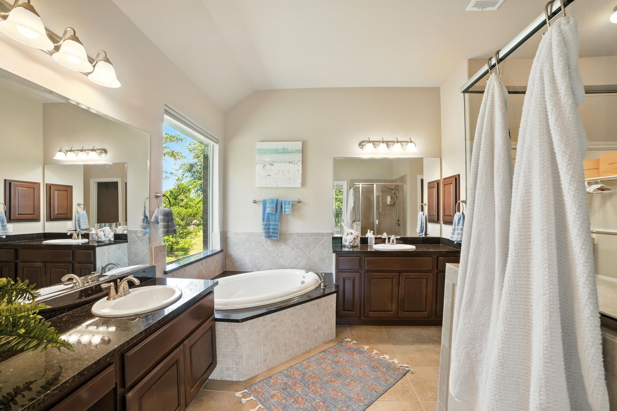 107 Tylee Circle Bastrop, TX 78602 - Photo 30 of 40 Bathroom with a shower stall, a garden tub, two vanities, and tile patterned floors