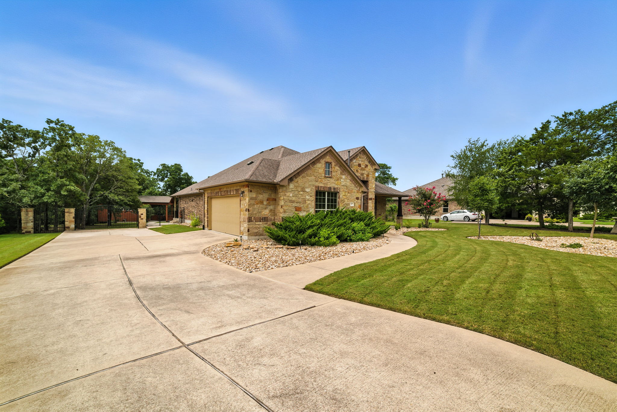 107 Tylee Circle Bastrop, TX 78602 - Photo 5 of 40 View of front of property featuring a front lawn, driveway, a garage, brick siding, and stone siding