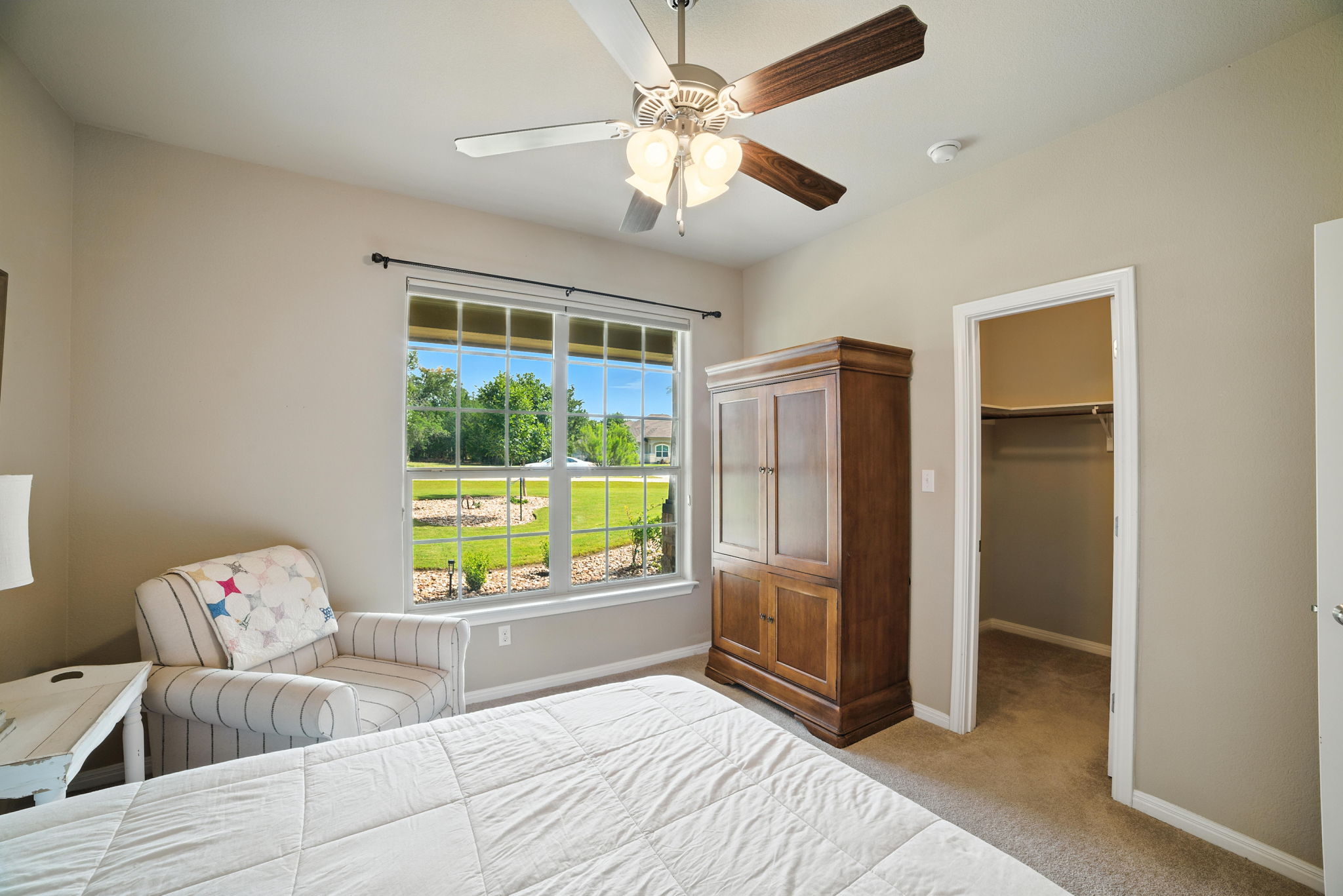 107 Tylee Circle Bastrop, TX 78602 - Photo 8 of 40 Bedroom with light carpet, a walk in closet, and a ceiling fan