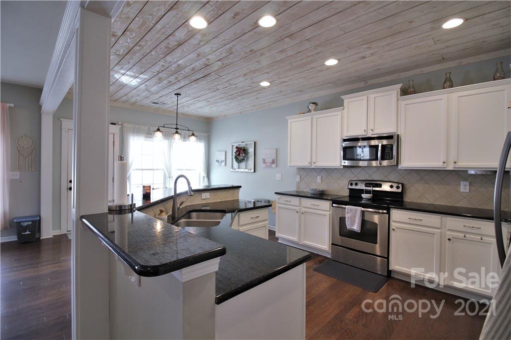78071 Rillstone Drive Lancaster, SC 29720 - Photo 3 of 25 a kitchen with stainless steel appliances granite countertop a sink a stove and cabinets
