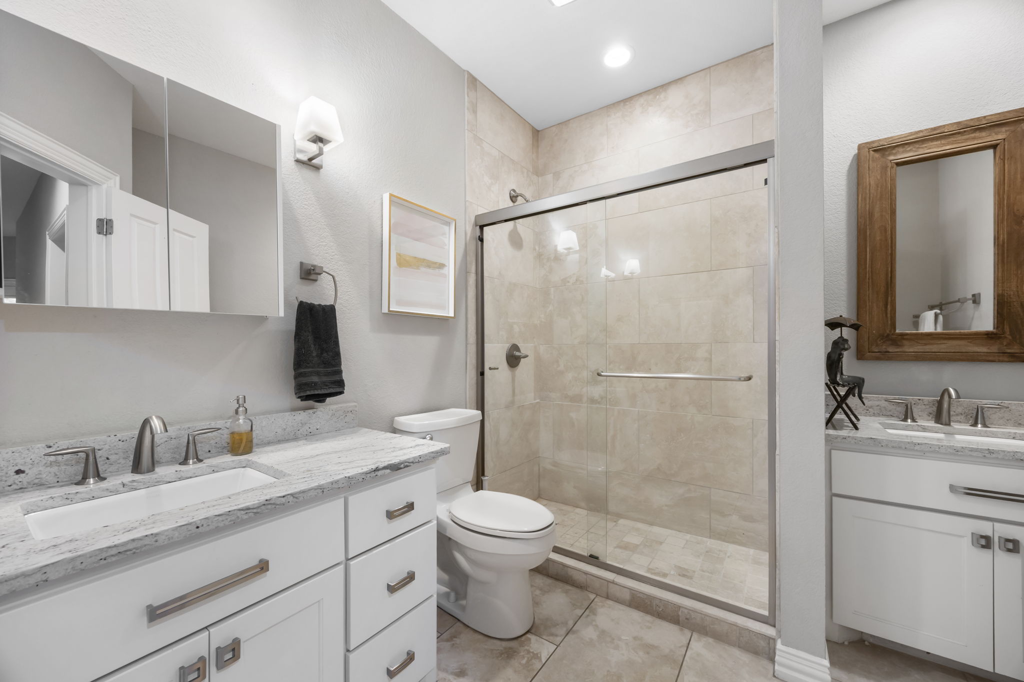 1910 Rue De St Tropez, Unit 6 Austin, TX 78746 - Photo 29 of 37 Dual vanities and a spacious glass-enclosed shower elevate this polished primary bathroom.