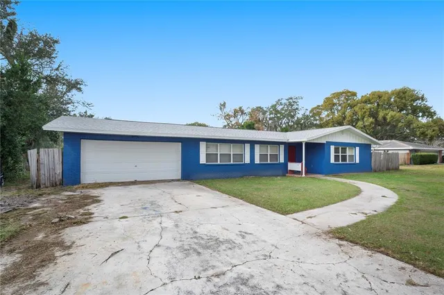 a view of a yard in front of a house with a large tree