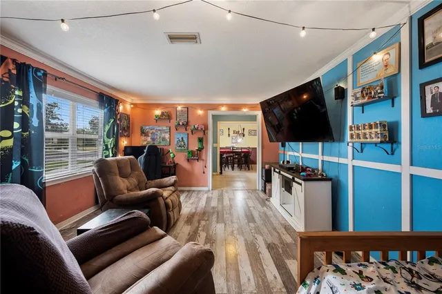 a living room with furniture a flat screen tv and a floor to ceiling window
